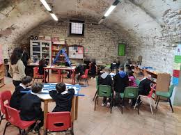 I bambini della Ludoteca di Gubbio seduti intorno ai tavoli a lavorare ad un progetto creativo